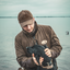 duck hunter wearing the heavyweight waxed canvas hat and petting a black lab in a duck hunting scene