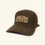 DECOY Waxed Canvas 7-panel Hat with leather strap and DECOY patch front view on cream background
